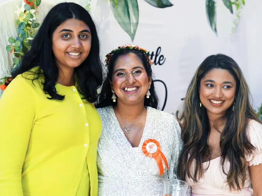 Three smiling women together at an event