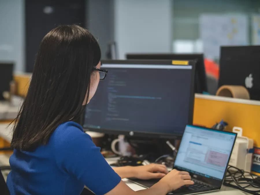 A woman developer writing code at her workstation