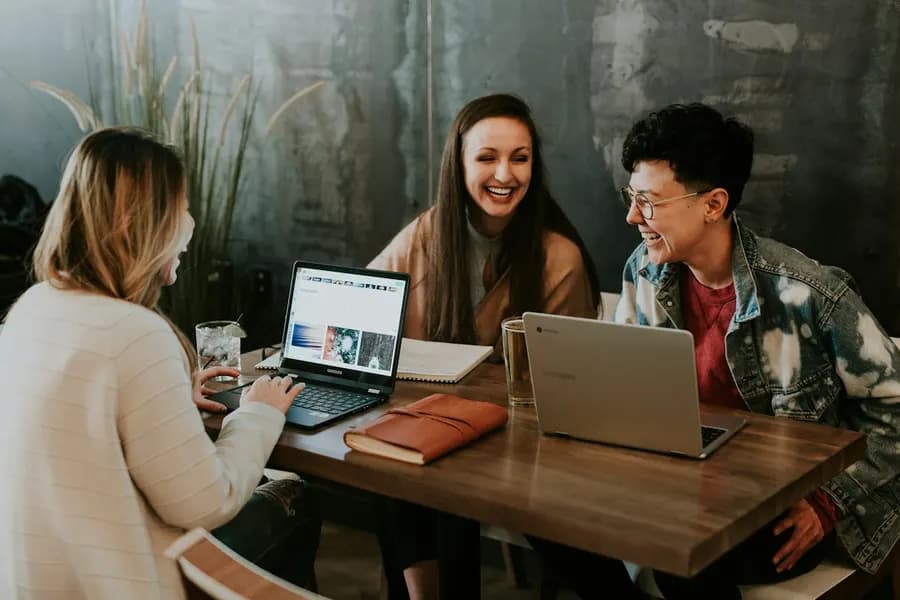 Colleagues laughing together around a meeting table